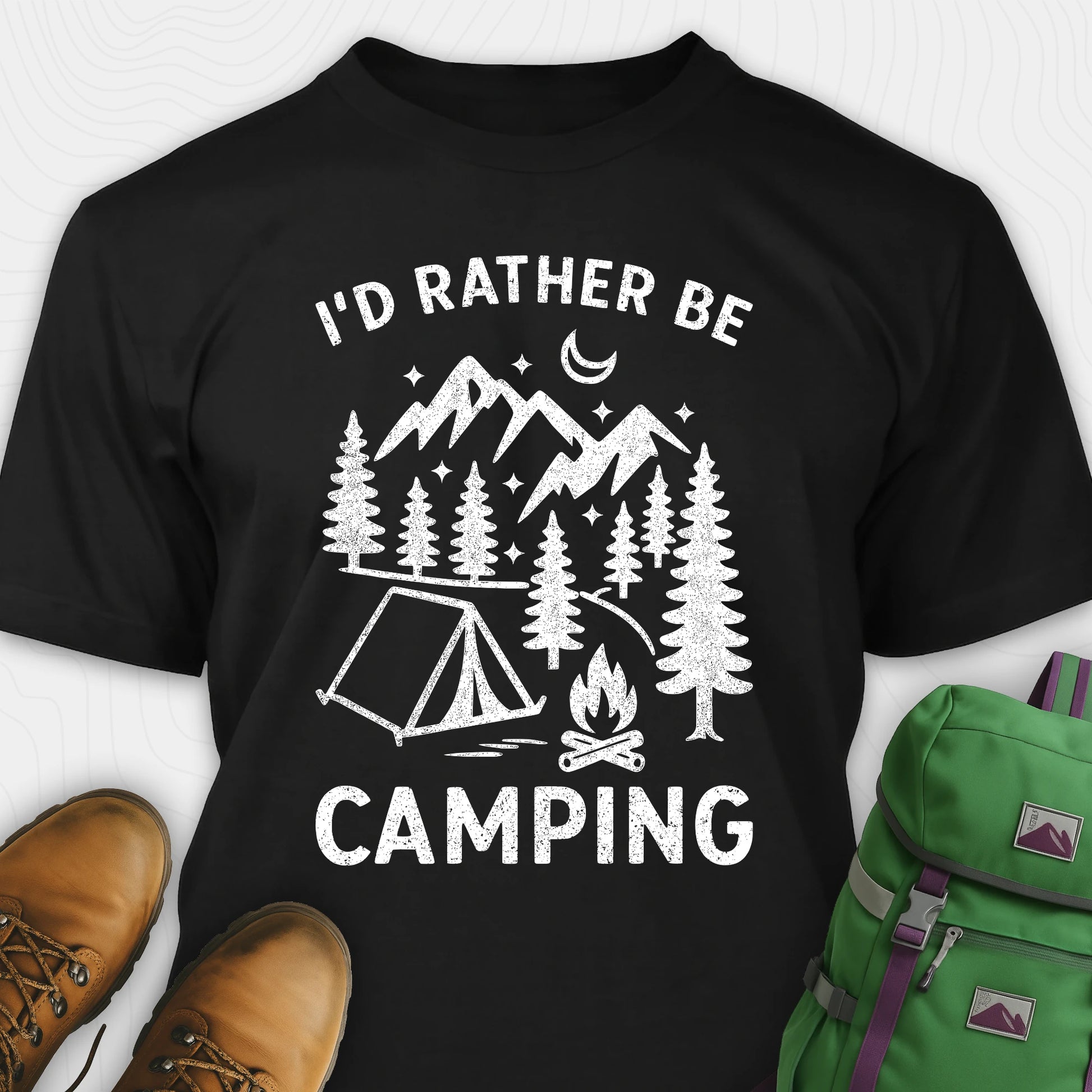 Black t-shirt with 'I'd Rather Be Camping' design, boots, and green backpack on a white background