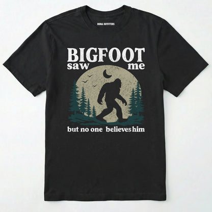 Black bigfoot saw me shirt with a vintage outdoor sasquatch in the forest graphic on a white background.