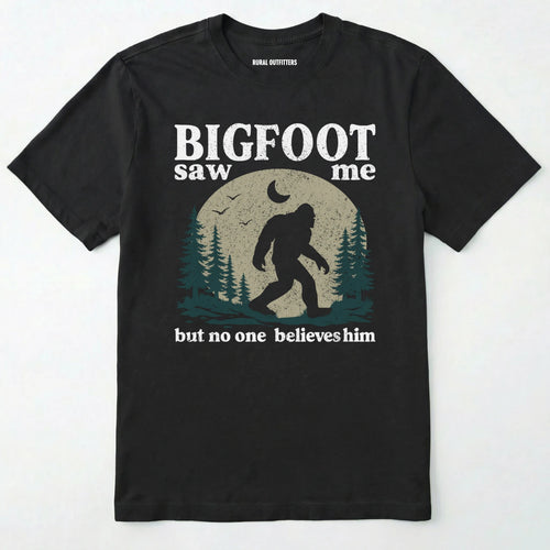 Black bigfoot saw me shirt with a vintage outdoor sasquatch in the forest graphic on a white background.