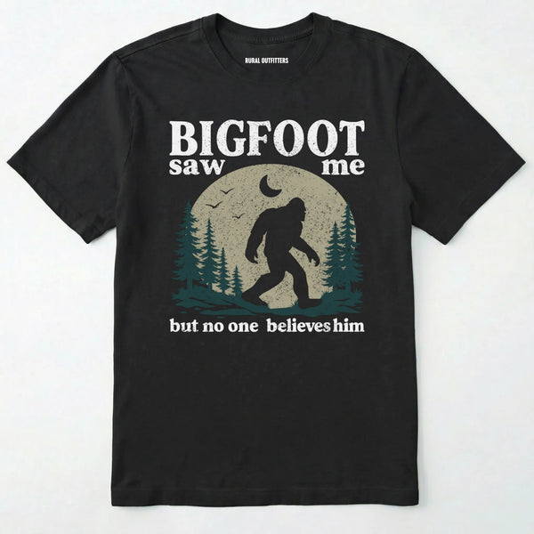 Black bigfoot saw me shirt with a vintage outdoor sasquatch in the forest graphic on a white background.