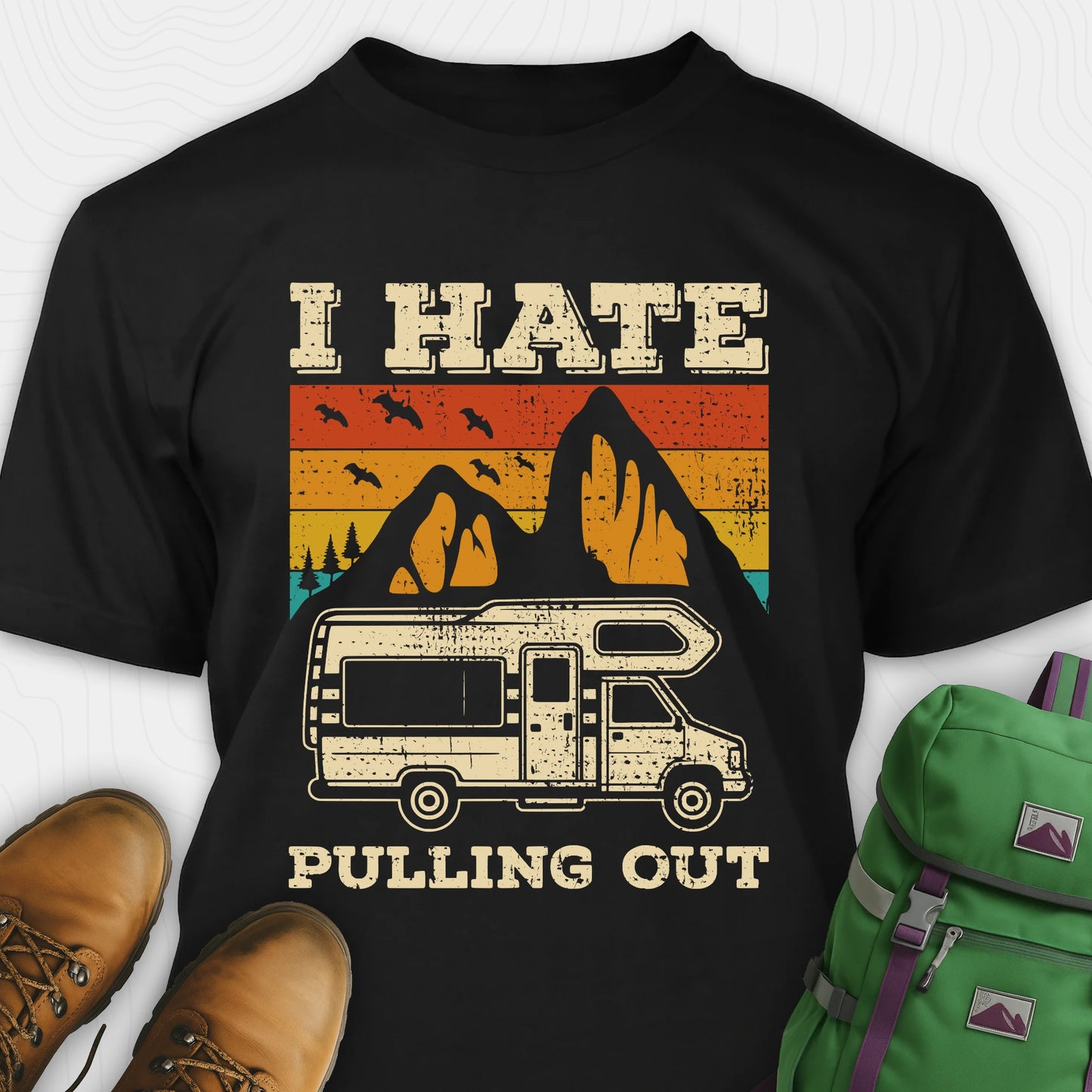Black I hate pulling out shirt with a graphic design of an RV and mountains, displayed with brown boots and a green backpack.