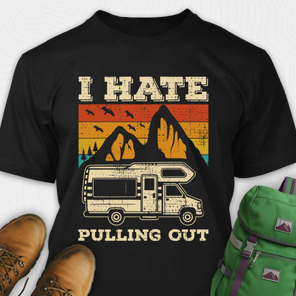 Black I hate pulling out shirt with a graphic design of an RV and mountains, displayed with brown boots and a green backpack.
