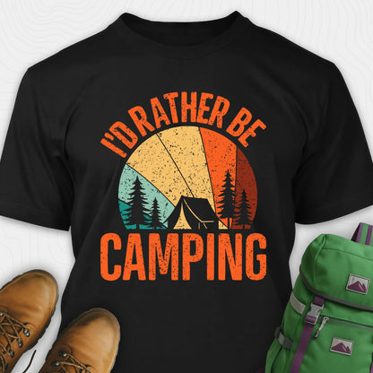 Black t-shirt with 'I'd Rather Be Camping' design, green backpack, and brown boots on a white background