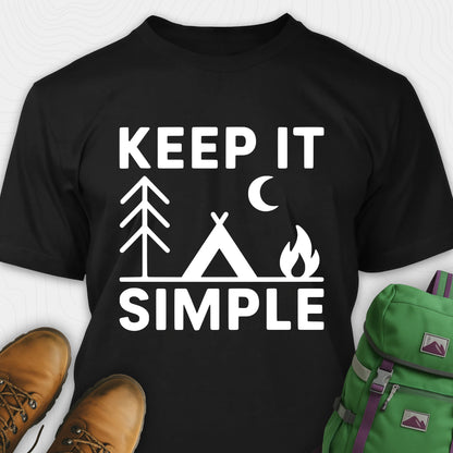 Black keep it simple camping t-shirt with tent and campfire graphic with boots, and a backpack on either side on a white background