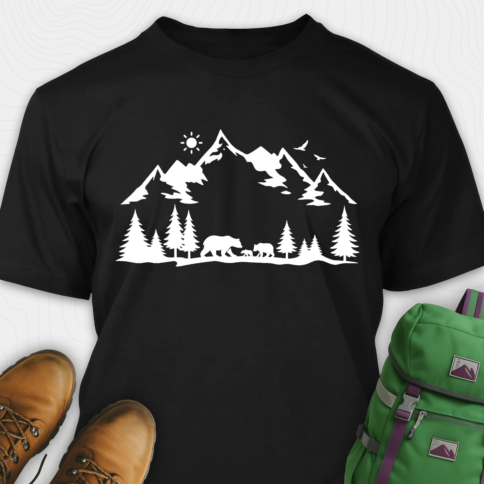 Black wildlife t-shirt with white mountain and bear design, paired with brown boots and a green backpack.