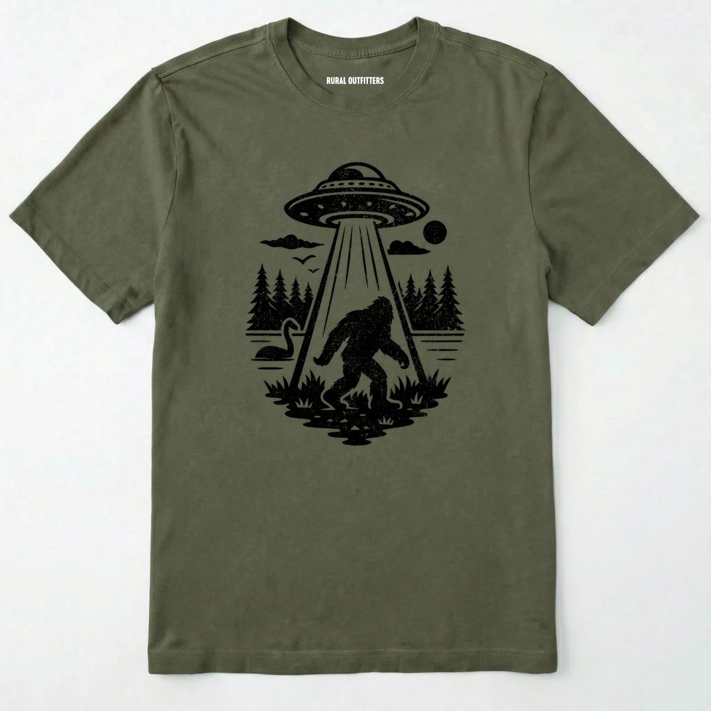 Military Green monster shirt with Bigfoot, a forest scene, and a UFO beam graphic on a white background.