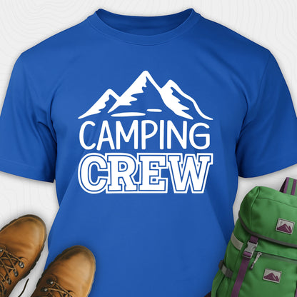 Blue camping crew t-shirt with 'Camping Crew' text and mountain graphic, paired with hiking boots and a green backpack.