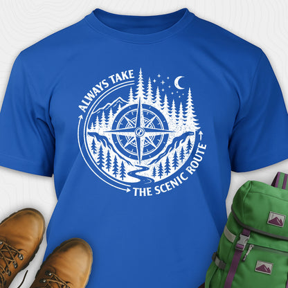 Blue always take the scenic route t-shirt with compass graphic and text, paired with hiking boots and a green backpack.