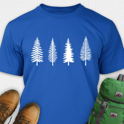 Royal blue pine tree shirt with white minimalist forest graphic, brown boots, and a green backpack on a light gray background