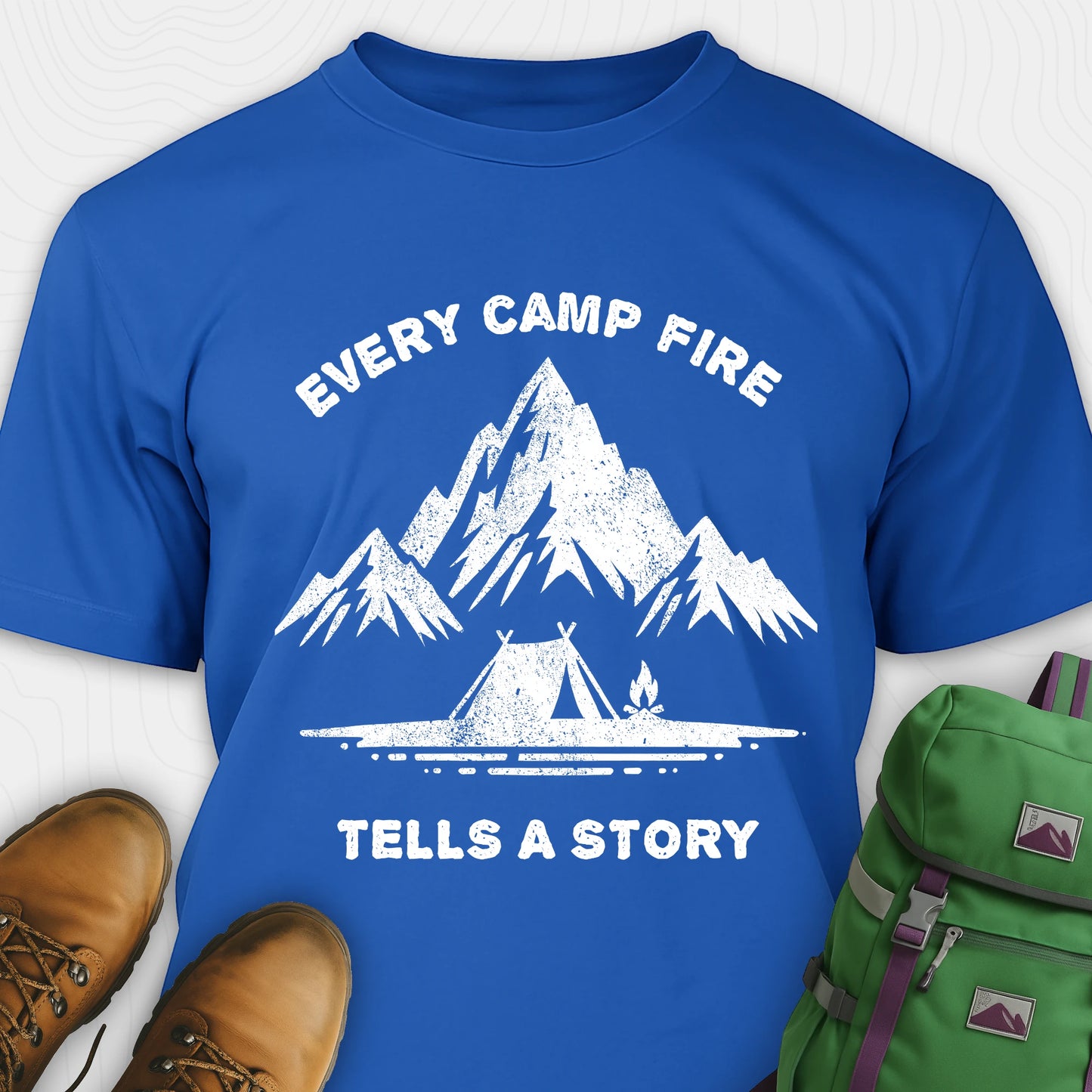 Blue campfire story shirt with mountains and tent graphic and "every camp fire tells a story" text