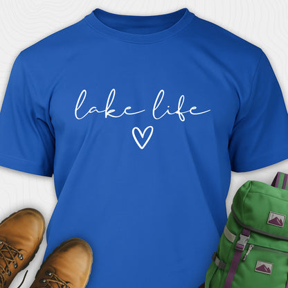 Royal blue lake life shirt with 'lake life' text and heart symbol, paired with brown boots and a green backpack on a white background.