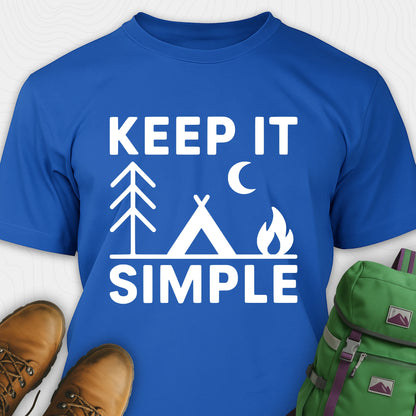 Royal blue keep it simple camping t-shirt with tent and campfire graphic with boots, and a backpack on either side on a white background