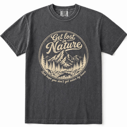 Grey mineral-wash t-shirt with a vintage cream-colored circular graphic on the chest that reads 'Get lost in Nature' above a mountain and pine tree illustration, with 'You hope you don't get eaten by bears' below.