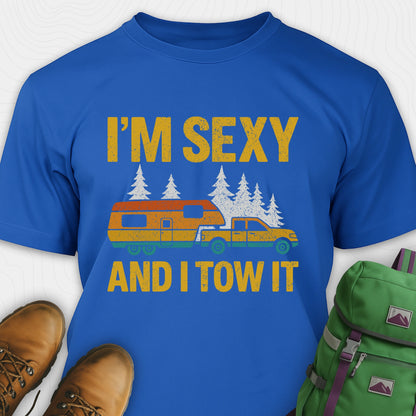 Royal blue fifth wheel t-shirt with “I’m Sexy and I Tow It” in distressed yellow text and a retro truck towing a camper graphic.