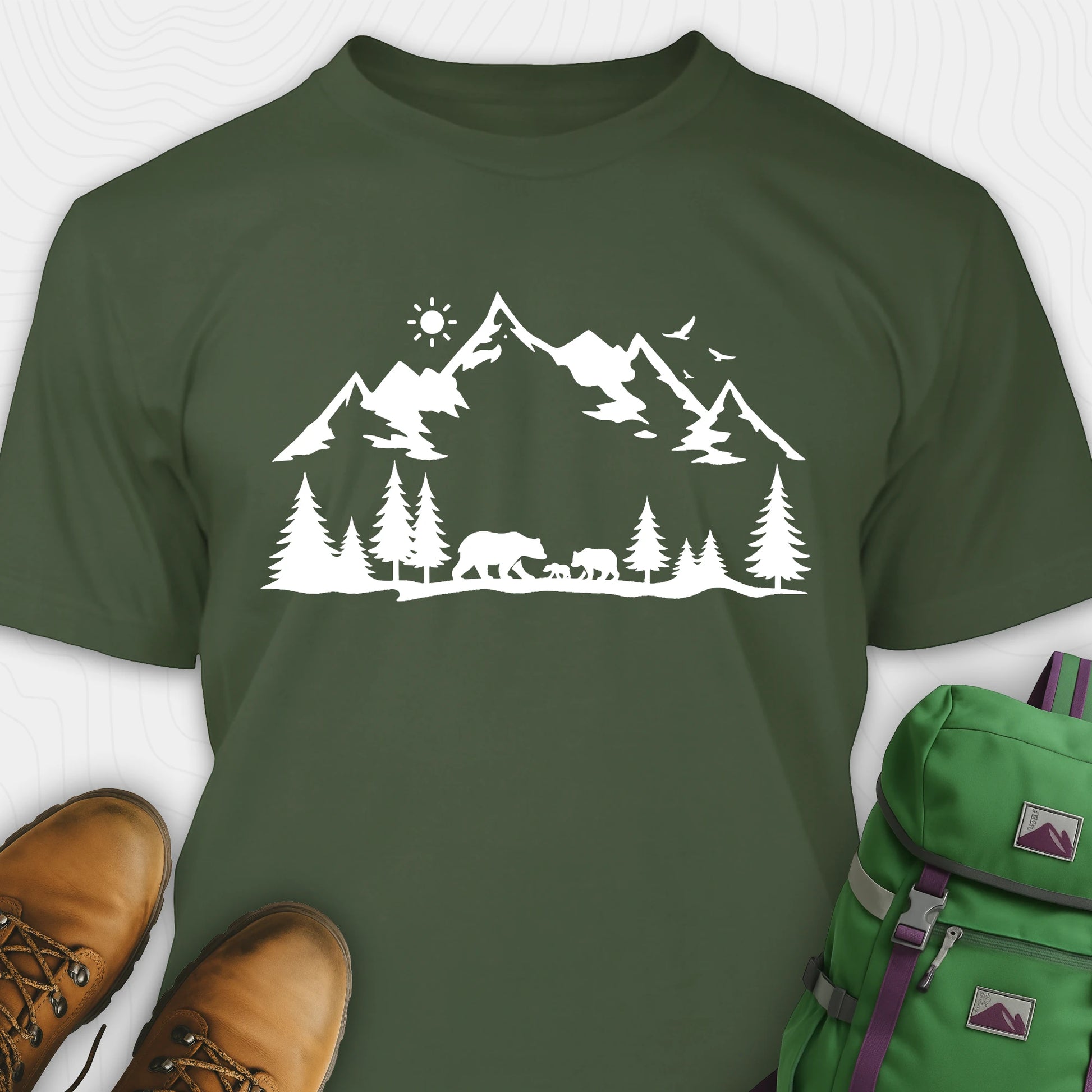 Military green wildlife t-shirt with white mountain and bear design, paired with brown boots and a green backpack.