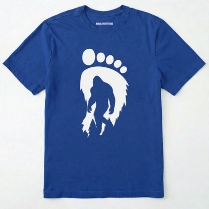 Royal bigfoot t-shirt with cryptid-themed footprint graphic and sasquatch silhouette on a white background.