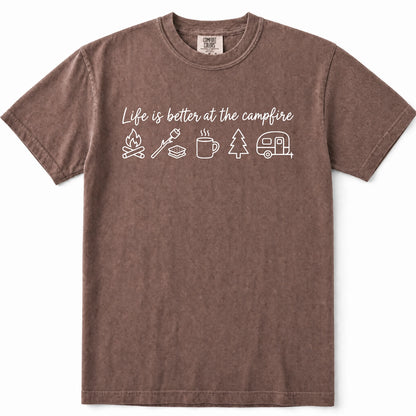 Espresso short-sleeve crewneck t-shirt in a washed, heathered brown color, featuring a white graphic print on the chest that reads 'Life is better at the campfire' above simple icons of a campfire, roasting marshmallow, mug, pine tree, and camper trailer.