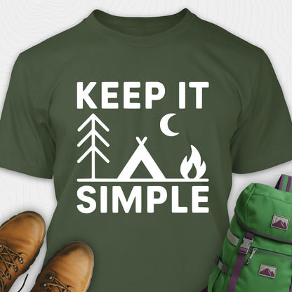 Military green keep it simple camping t-shirt with tent and campfire graphic with boots, and a backpack on either side on a white background