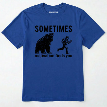 Royal motivational t-shirt with bear and person graphic and text 'sometimes motivation finds you' on a white background.