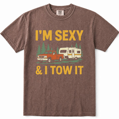 Espresso heathered t-shirt with a graphic print that reads 'I'M SEXY & I TOW IT' in yellow text, featuring an illustration of an orange pickup truck towing a cream camper trailer with green pine trees in the background.