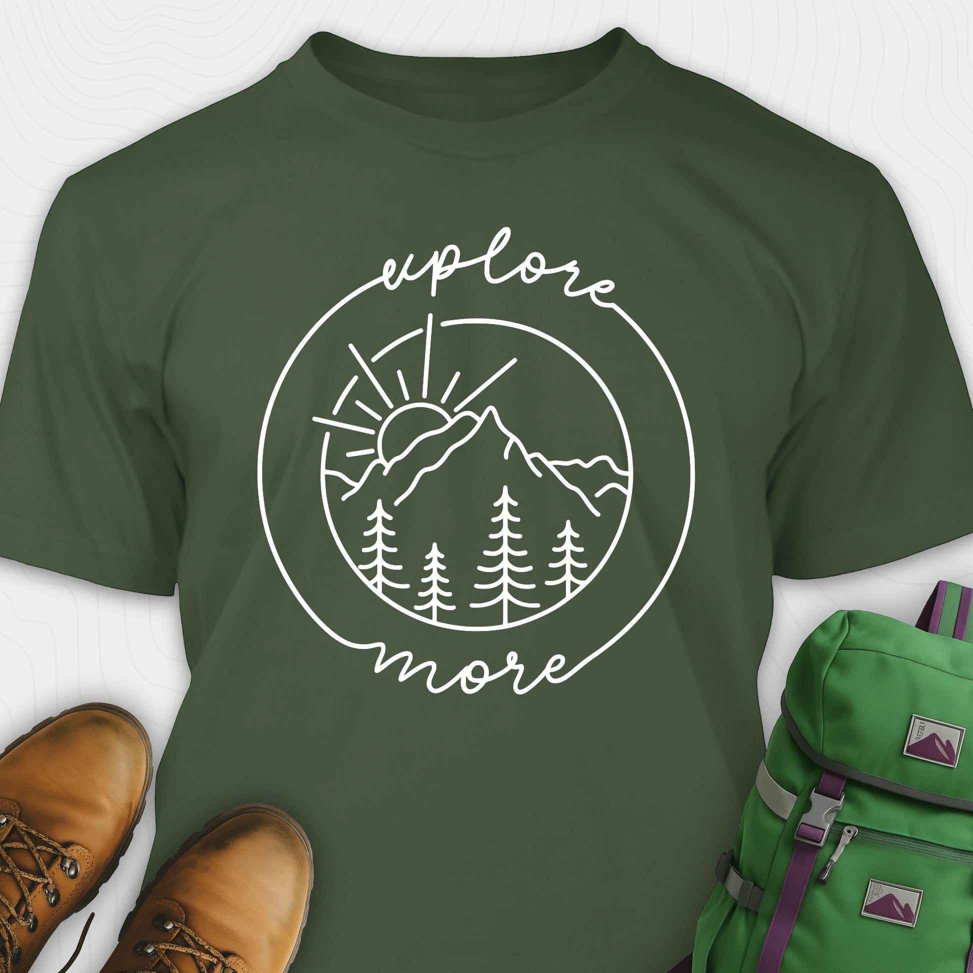 Green explorer shirt with 'explore more' graphic design, brown boots, and green backpack on a white background