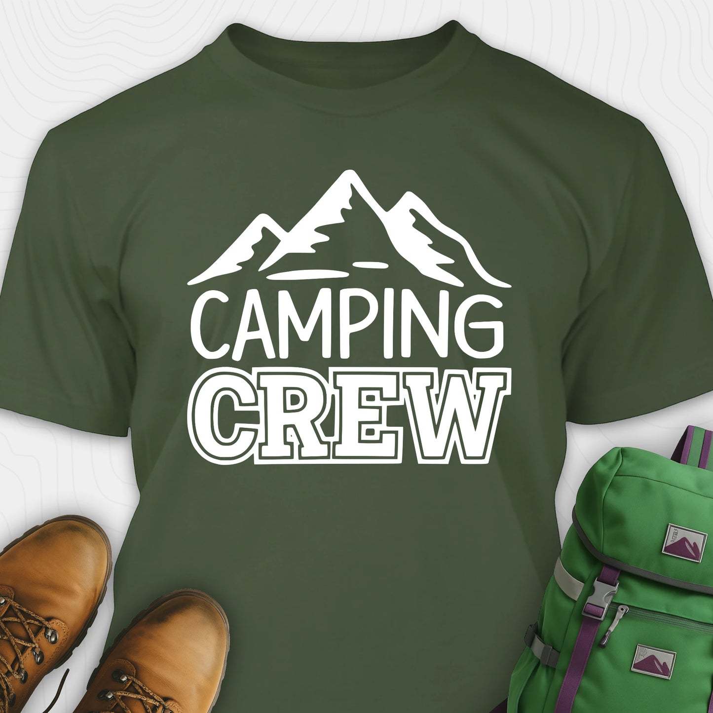 Green camping crew t-shirt with 'Camping Crew' text and mountain graphic, paired with hiking boots and a green backpack.