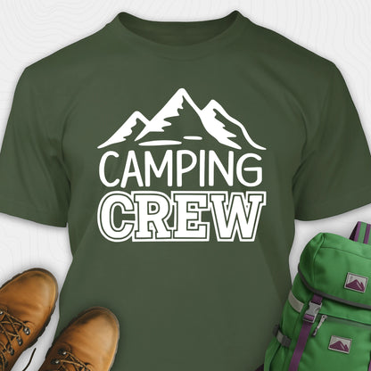 Green camping crew t-shirt with 'Camping Crew' text and mountain graphic, paired with hiking boots and a green backpack.