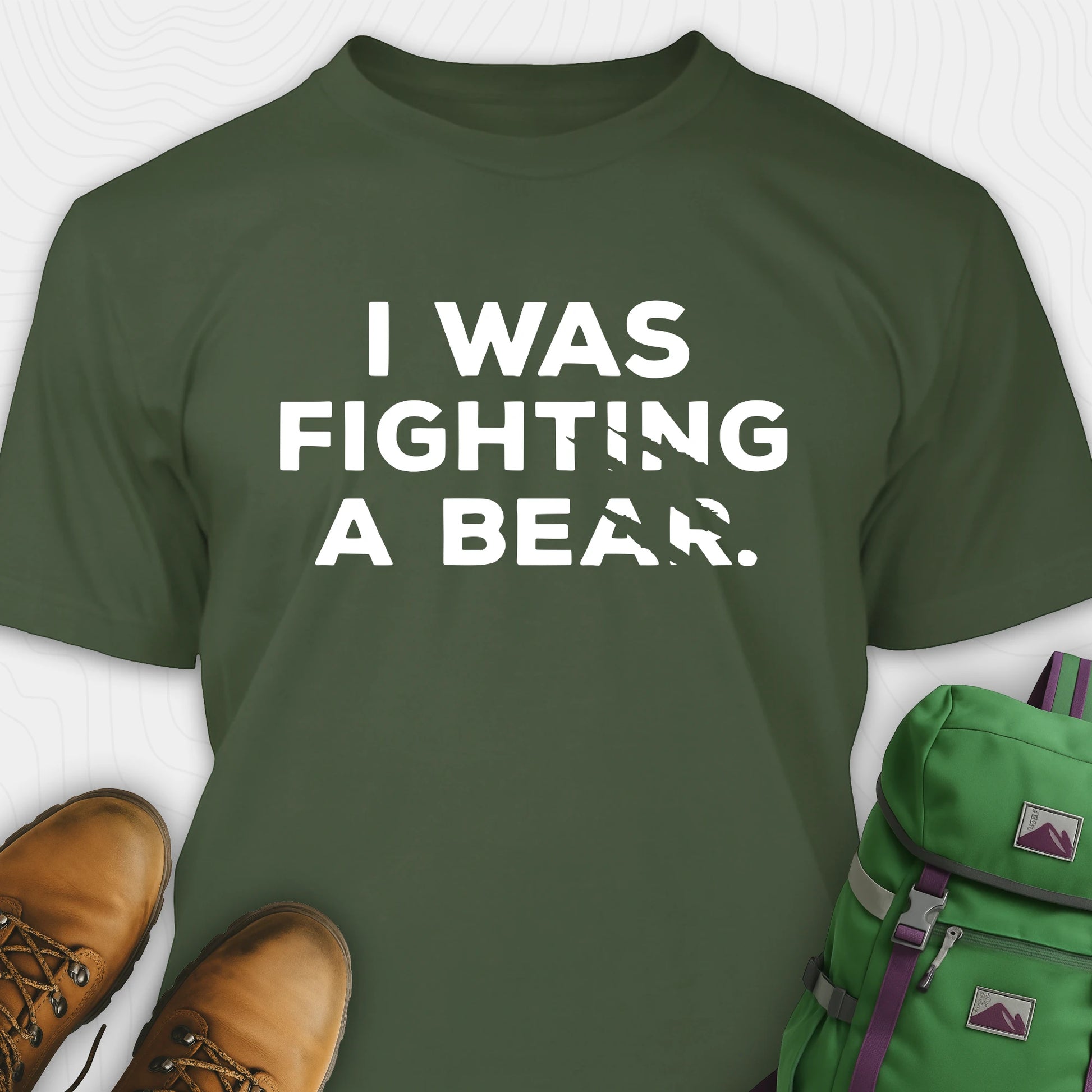 Green I was fighting a bear shirt with a bear scratch mark graphic, paired with brown boots and a green backpack on a white background.