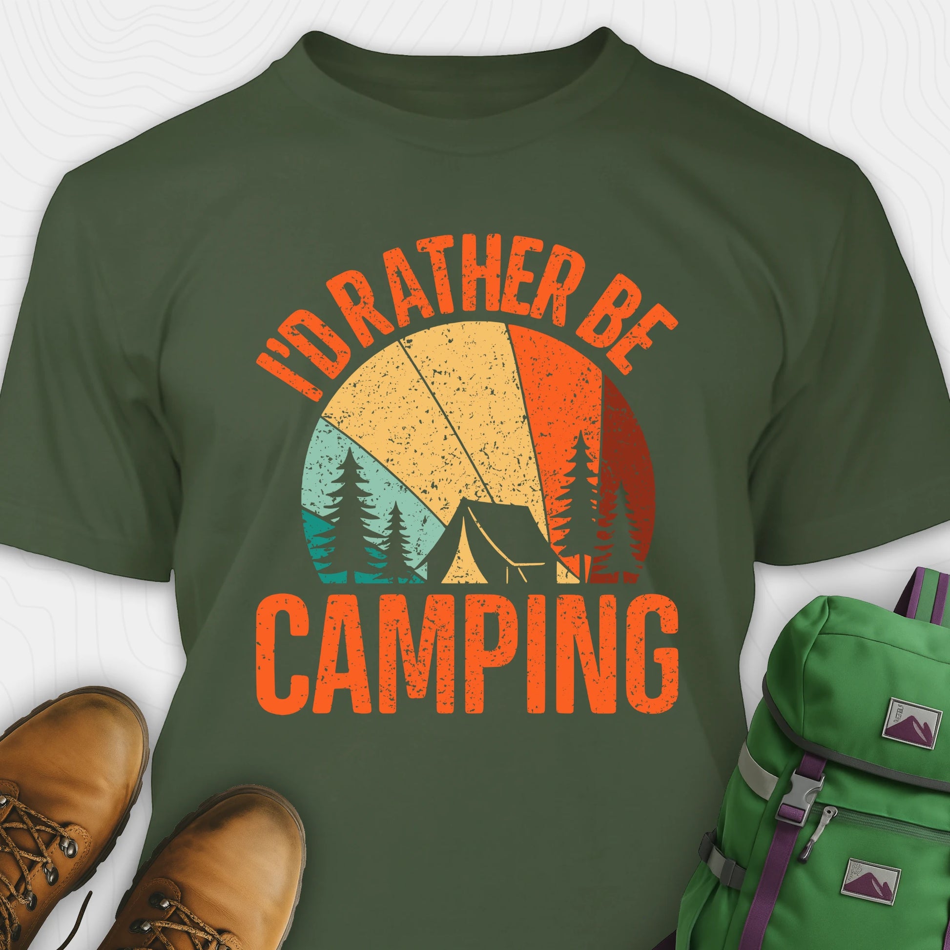 Green t-shirt with 'I'd Rather Be Camping' design, brown boots, and green backpack on a white background