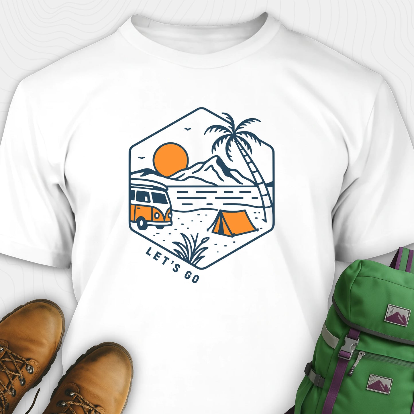 White let’s go t-shirt with retro camper van and sunset graphic, and green backpack on a white background