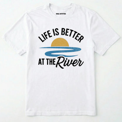 White river shirt with 'life is better at the river' design, paired with brown boots and a green backpack on a light grey background.