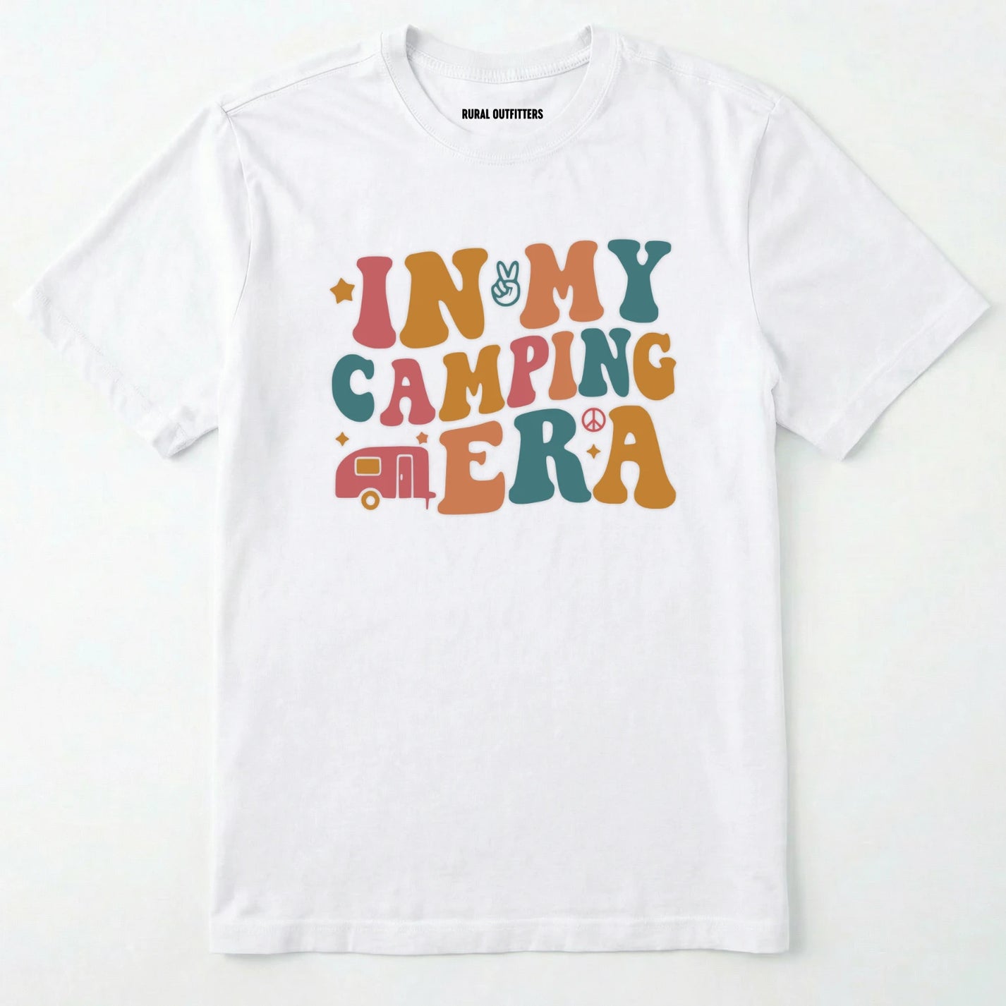 White cute camping shirt with colorful retro ⊜in my camping era⊝ graphic on a white background.