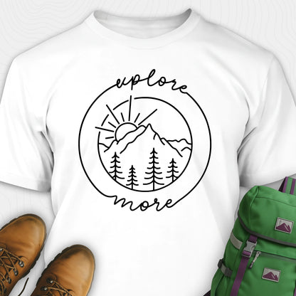 White explorer shirt with 'explore more' graphic design, brown boots, and green backpack on a white background