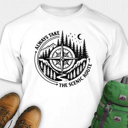 White always take the scenic route t-shirt with compass graphic and text, paired with hiking boots and a green backpack.