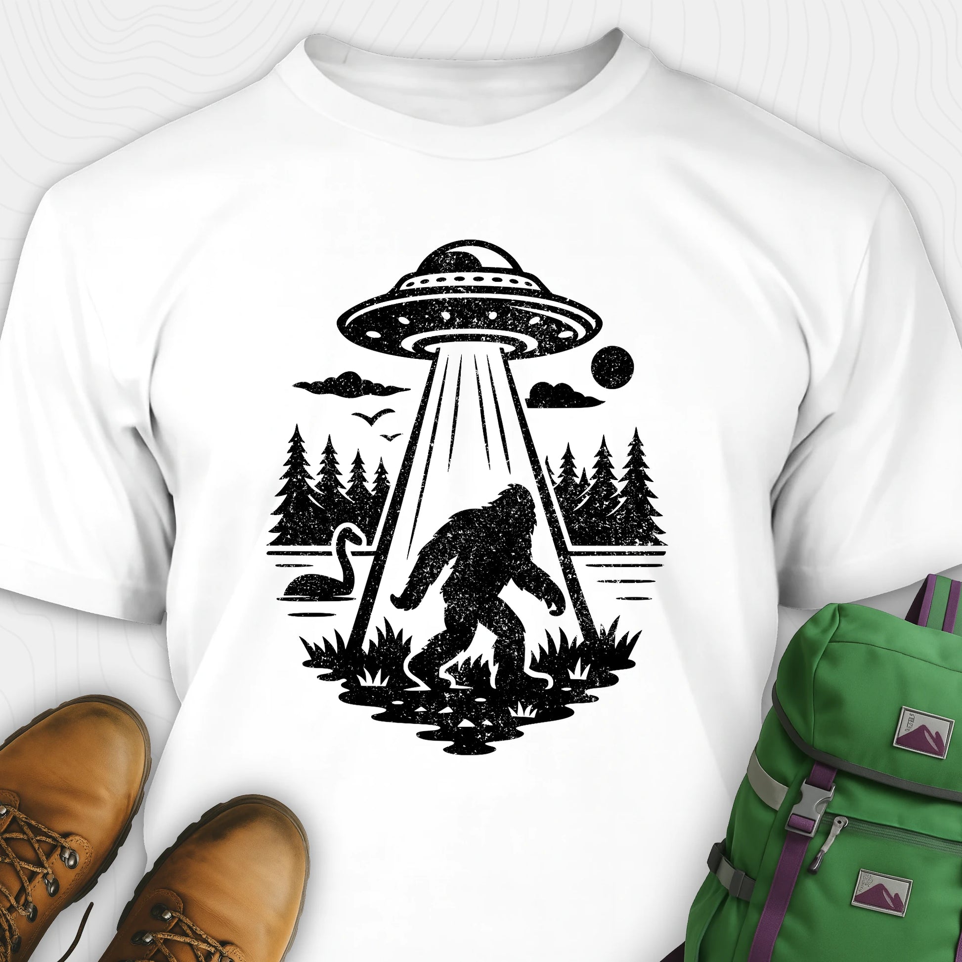 White monster shirt with bigfoot, forest scene, and ufo beam graphic