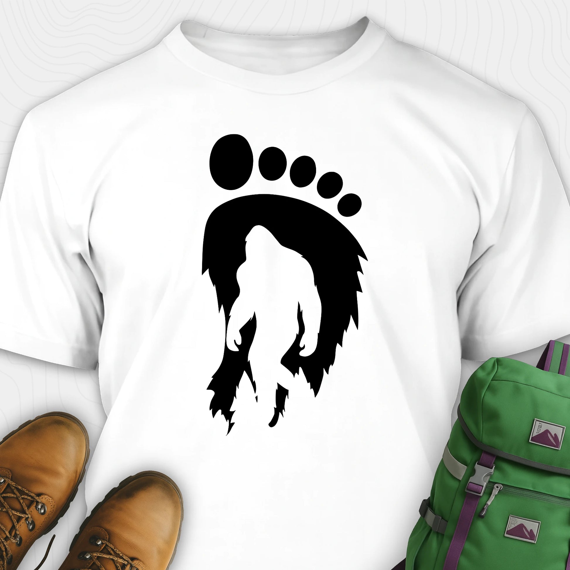 White bigfoot t-shirt with cryptid themed footprint graphic and sasquatch silhouette