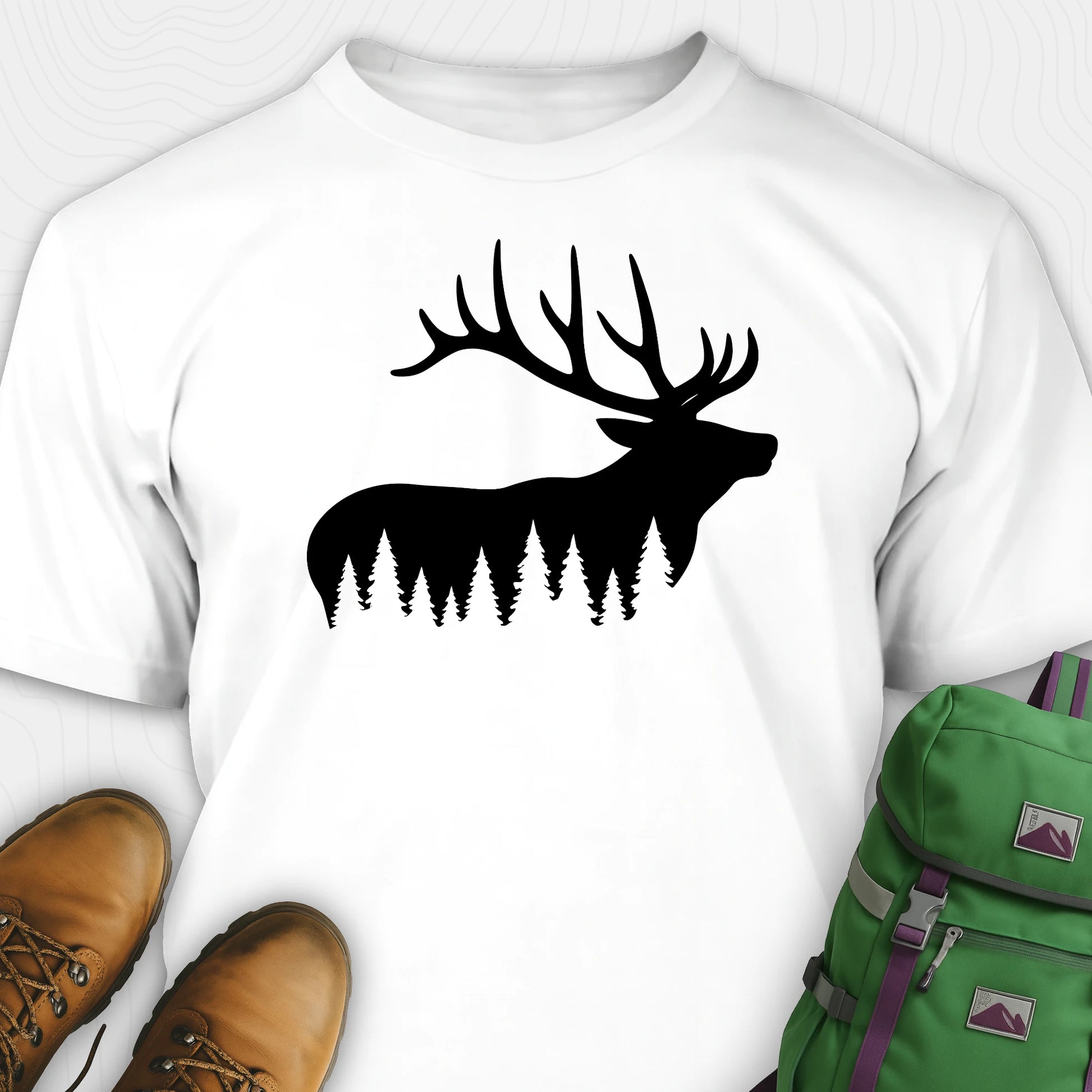 White elk shirt with black elk silhouette design, paired with brown boots and a green backpack on a white background.