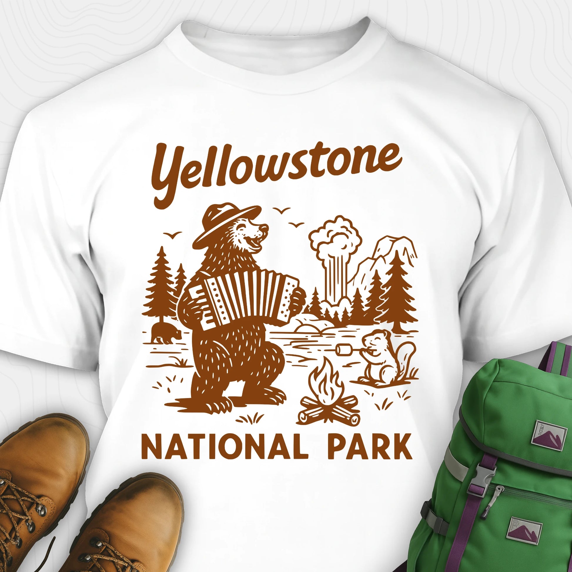 White t-shirt with a brown bear playing an accordion and “Yellowstone National Park” text, styled with hiking boots and a green backpack.