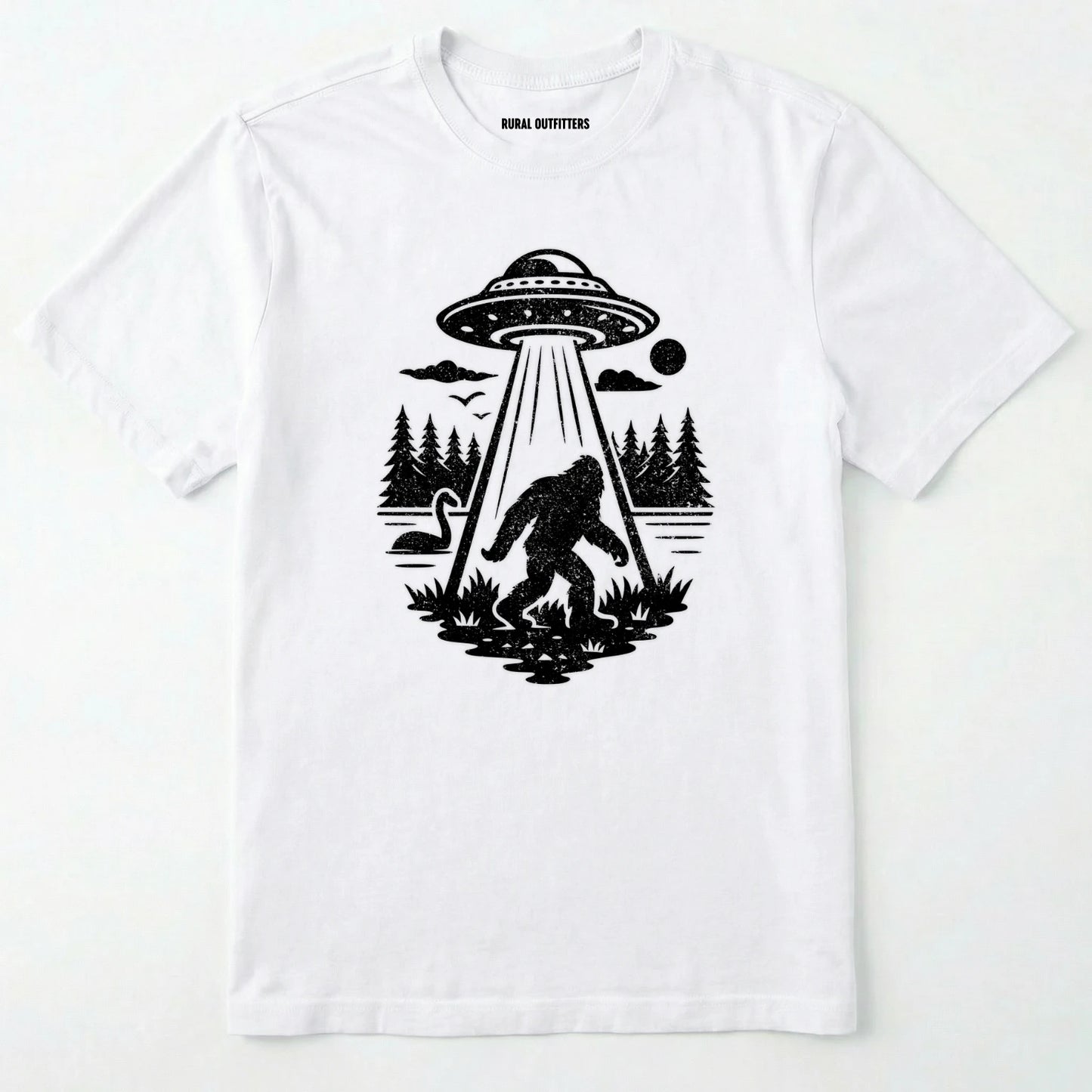 White monster shirt with Bigfoot, a forest scene, and a UFO beam graphic on a white background.