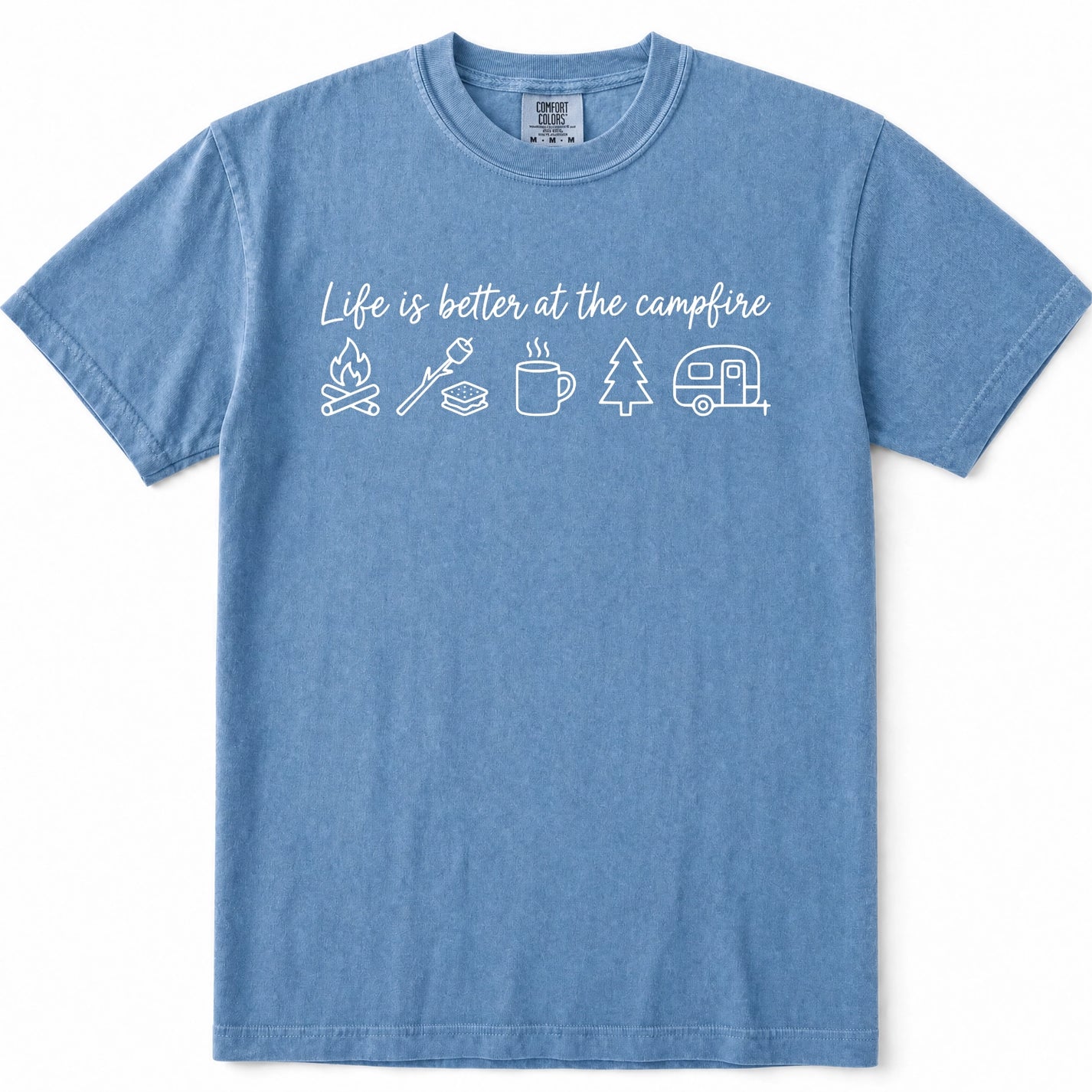 Blue Jean crewneck t-shirt with a white graphic print that reads 'Life is better at the campfire' above simple icons of a campfire, roasting stick, mug, tree, and camper trailer, shown on a plain white background.
