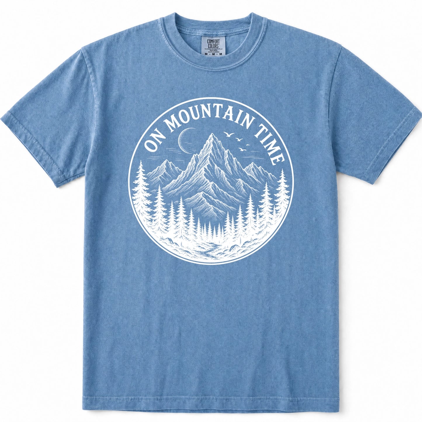 Blue Jean short-sleeve crewneck t-shirt featuring a white circular graphic on the chest with a mountain, pine trees, birds, and the text 'ON MOUNTAIN TIME'.