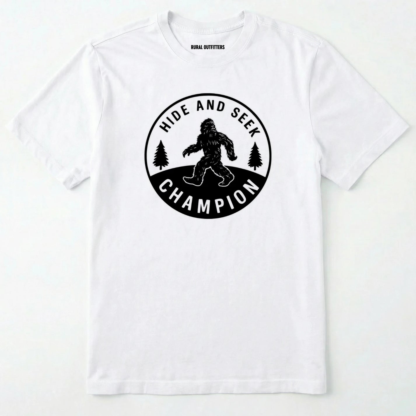 White bigfoot hide and seek champion shirt with forest emblem on a white background.