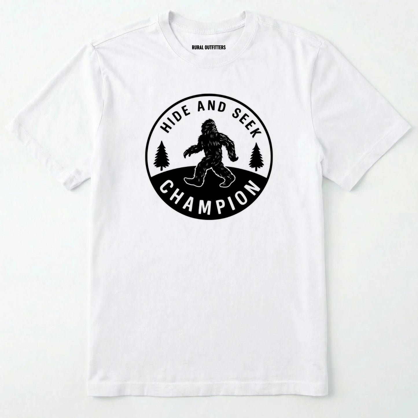 White bigfoot hide and seek champion shirt with forest emblem on a white background.