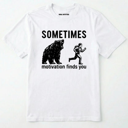 White motivational t-shirt with bear and person graphic and text 'sometimes motivation finds you' on a white background.