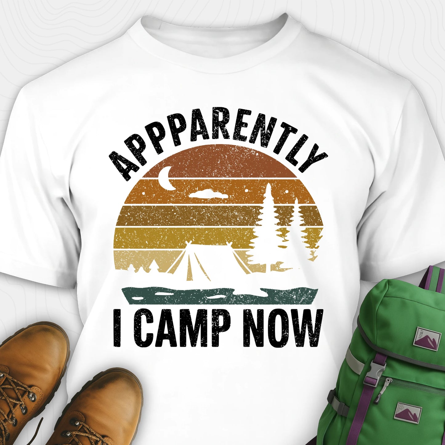 White t-shirt with “Apparently I Camp Now” in white text and a vintage sunset camping scene with tent, trees, and moon.