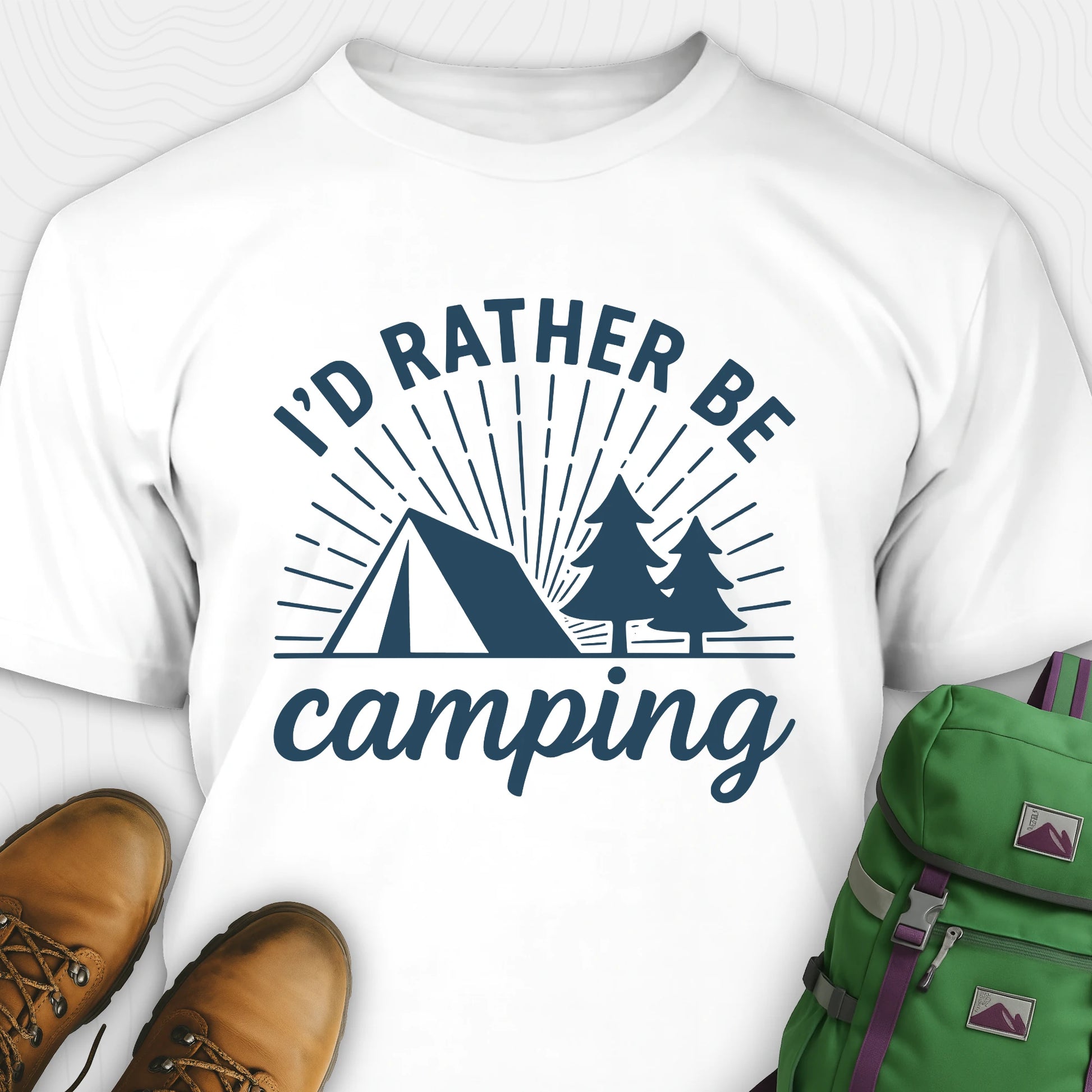 White camping shirt with 'I'd Rather Be Camping' design, brown boots, and green backpack on a white background
