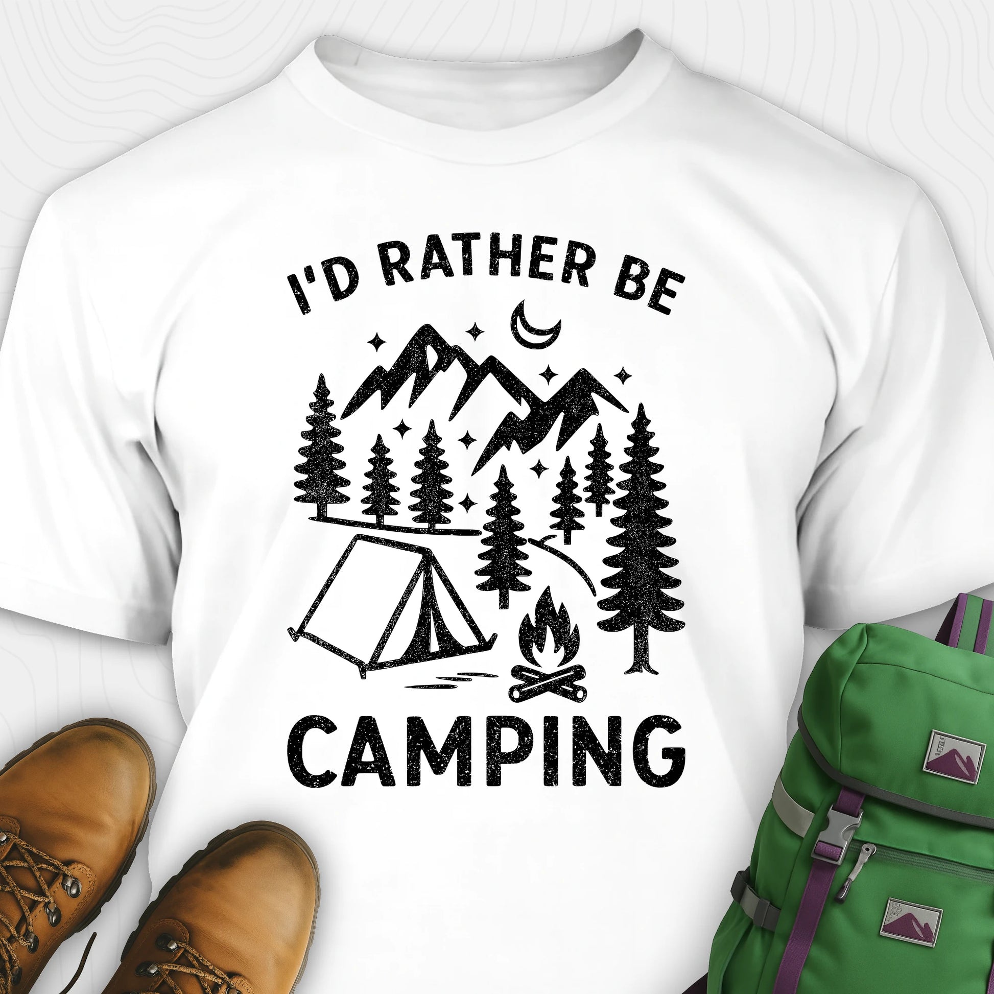 White t-shirt with 'I'd Rather Be Camping' design, brown boots, and green backpack on a white background