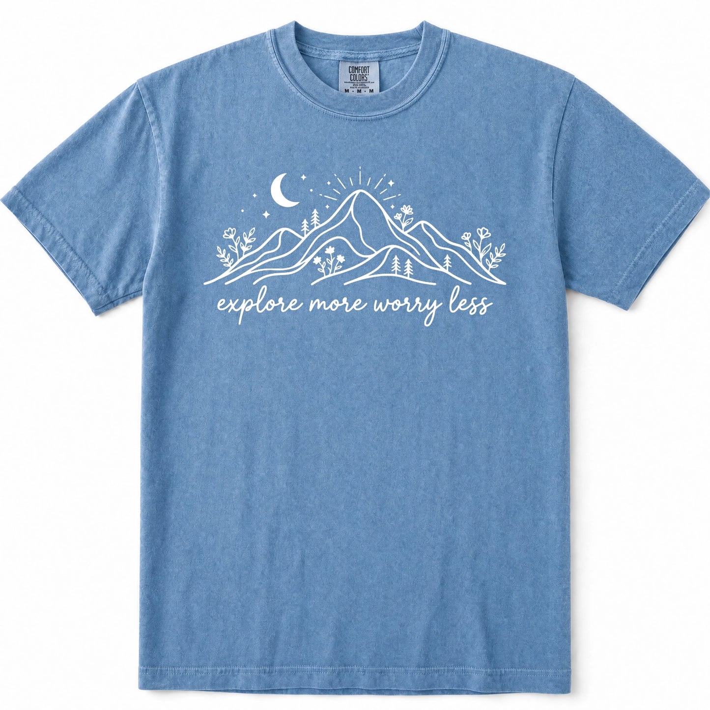 Blue Jean short-sleeve t-shirt with a white graphic of mountains, a crescent moon, stars, and the text 'explore more worry less' printed on the chest, displayed flat against a white background.