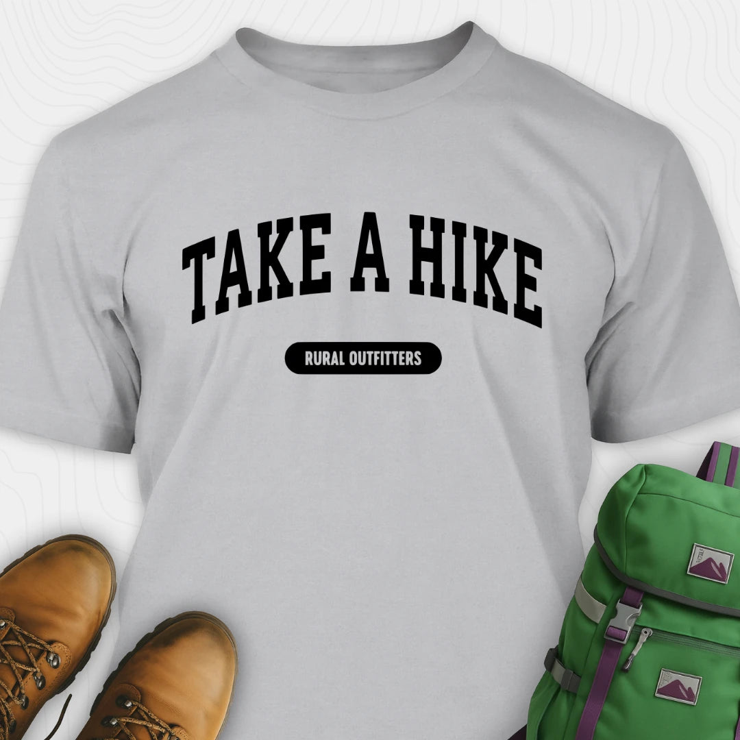 Gray t-shirt with 'Take a Hike' text, brown boots, and green backpack on a white background