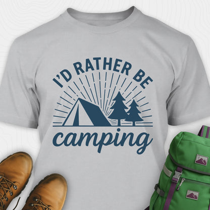 Sport grey camping shirt with 'I'd Rather Be Camping' design, paired with hiking boots and a green backpack on a white background.